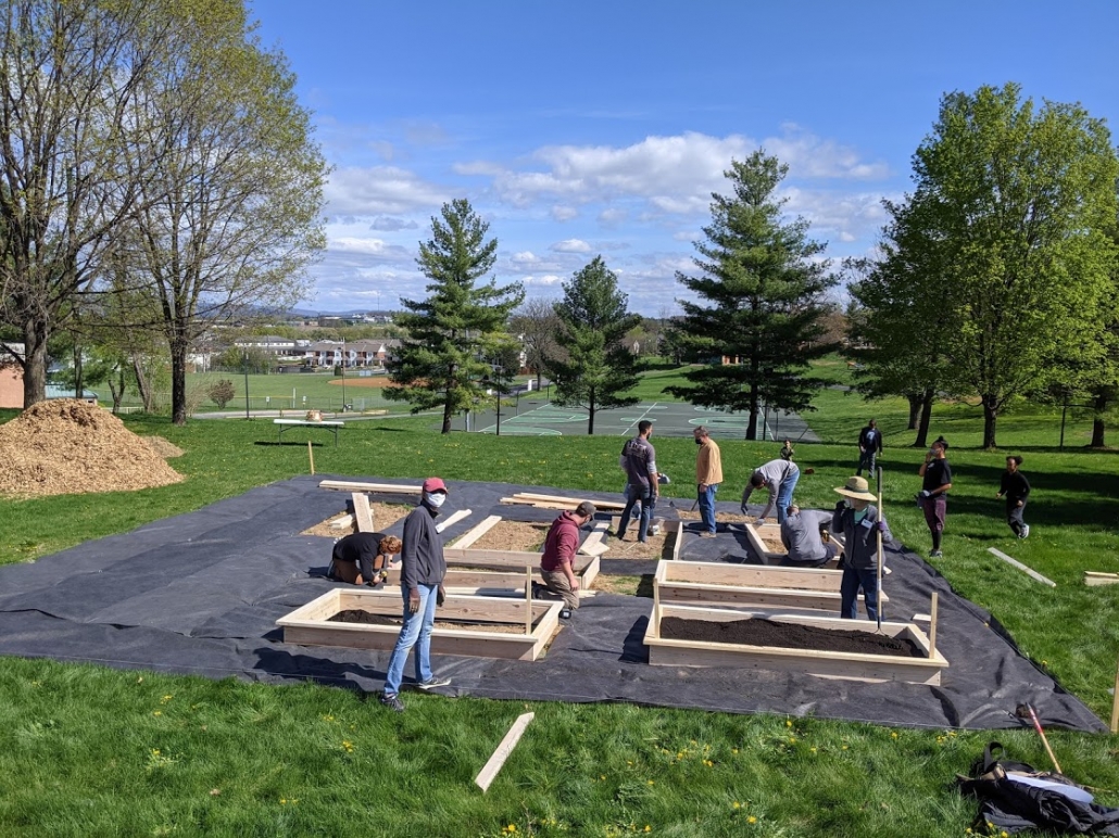 Volunteers build garden boxes, fill boxes with soil, and help with the Kelley Street garden April 17 during community build day