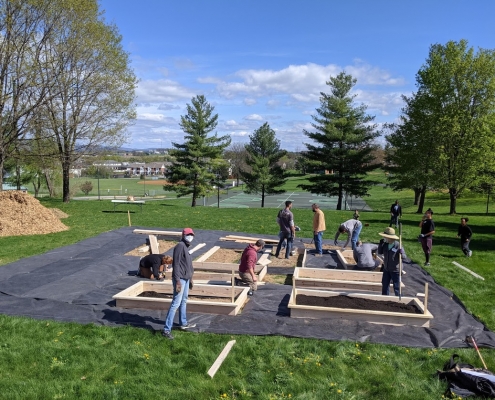 Volunteers build garden boxes, fill boxes with soil, and help with the Kelley Street garden April 17 during community build day